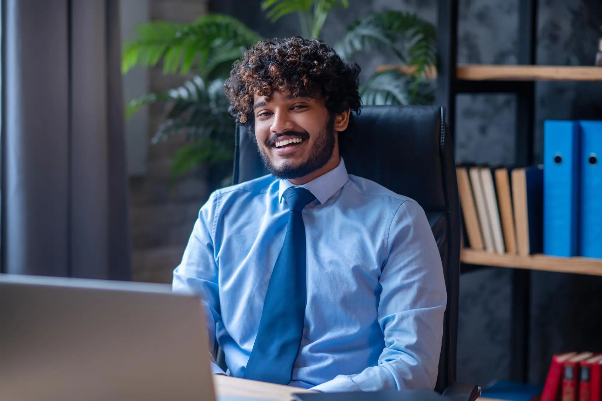 Expert digital souriant en chemise bleue représentant l’agence web premium Alirna en Tunisie
